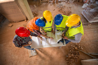 Top view of construction team with colorful hard hat on building construction